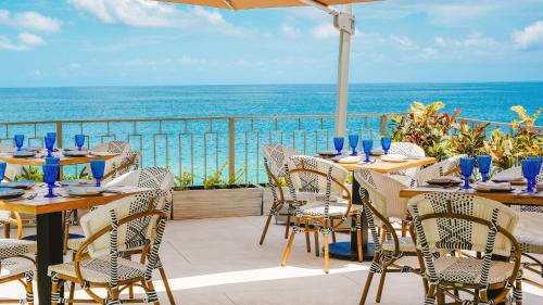 a patio with tables and chairs with the ocean in the background at La Puesta Sayulita in Sayulita