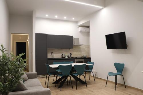 una cucina e un soggiorno con tavolo e sedie di IOLETTA HOUSE a Catania