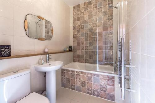 a bathroom with a toilet and a sink and a shower at Rockleigh Place in St Austell