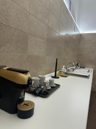 a kitchen counter with a sink and cups on it at La Casetta in Ordona