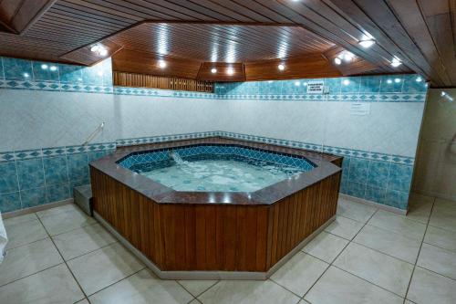 a jacuzzi tub in a bathroom with blue tiles at HANNA San Diego Apart Hotel in Florianópolis