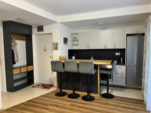 a kitchen with a wooden table and black and white cabinets at Apartman Winter Nights Vlašić in Vlasic