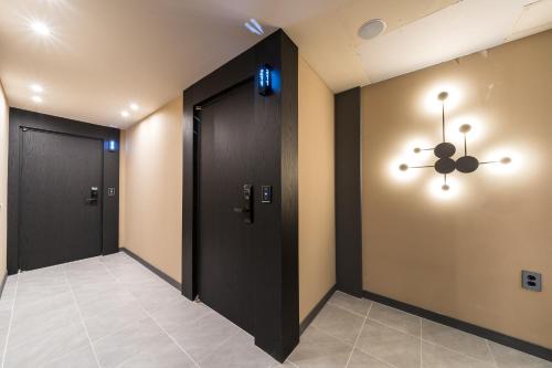 a hallway with two black doors and a chandelier at Hotel Rodem in Incheon