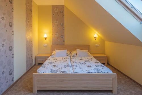 a bedroom with a large bed in a attic at Rozmann Family Panzió & Apartmanhaz in Sárvár