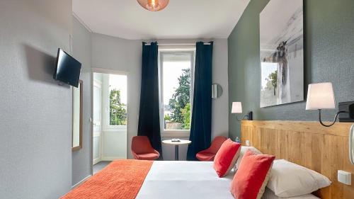 a bedroom with a bed with red pillows and a window at Hôtel Coeur De Loire in Nantes