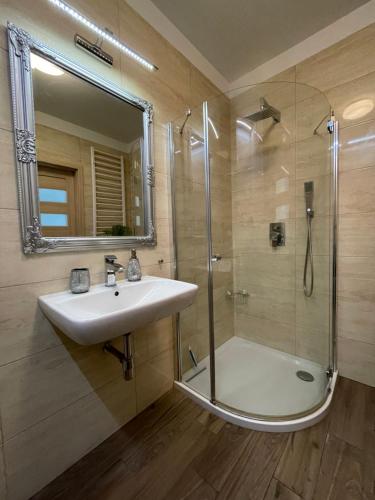 a bathroom with a sink and a shower with a mirror at Garbary 100 CITY CENTER Apartment, free parking, self check-in 24h in Poznań