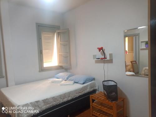 um pequeno quarto com uma cama e uma janela em Aconchego do Lar Centro BH Apto 633 Rua da Bahia 187 em Belo Horizonte