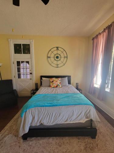 a bedroom with a large bed with a clock on the wall at Spacious One Bedroom Apartment in Soulard