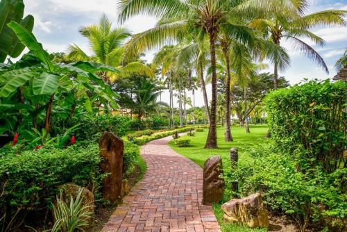 a brick path in a park with palm trees at Luxury in the Tropics that Sleeps 6 in El Chirú