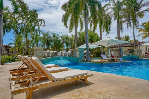 a group of lounge chairs next to a swimming pool at Luxury in the Tropics that Sleeps 6 in El Chirú