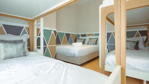 a bedroom with two bunk beds and a mirror at Pedra de Sal - Hostel & Suites in Rio Maior