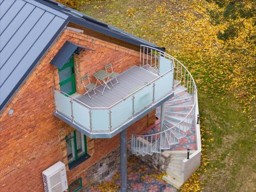 a building with a balcony with two chairs on it at Apteegimaja Apartment in Rõngu