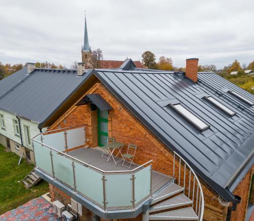 a house with a metal roof with a balcony at Apteegimaja Apartment in Rõngu