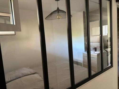 Cette chambre en verre dispose d'un lit et d'un lavabo. dans l'établissement Appartement Type T2 Bandol Port, à Bandol