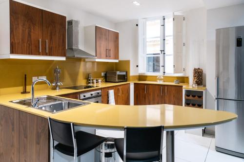 a kitchen with wooden cabinets and a yellow counter top at Modern Central 2BR Flat in Valletta in Valletta