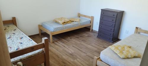 a bedroom with two bunk beds and a dresser at Casa Atlántida 2 Dorm. Deck con Parrillero, 3 de Playa Mansa in Atlántida