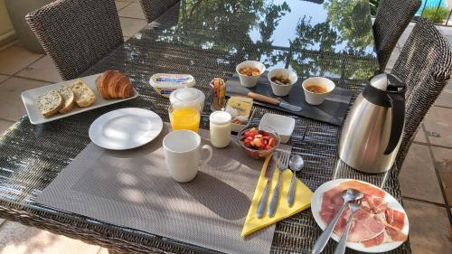 GigeanにあるLA VIGNERONNE DE GIGEANの朝食の食べ物と飲み物が置かれたテーブル