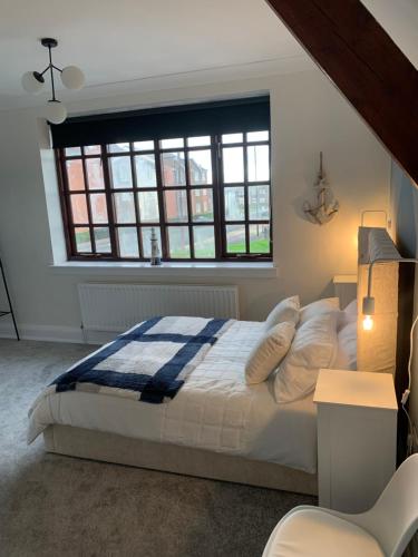 a bedroom with a bed and a large window at The Vicarage in Sunderland
