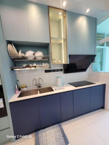 a kitchen with blue cabinets and a sink at Lee Batu Ferringhi Condominium in Batu Ferringhi