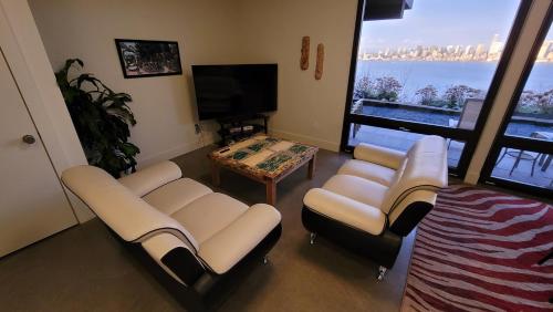 a living room with couches and a table and a tv at 180 degree, unobstructed bluff view! in Seattle