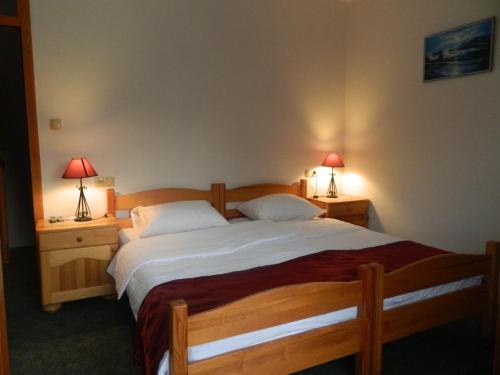 a bedroom with a large bed with two lamps on tables at Motel Jelčić in Čapljina