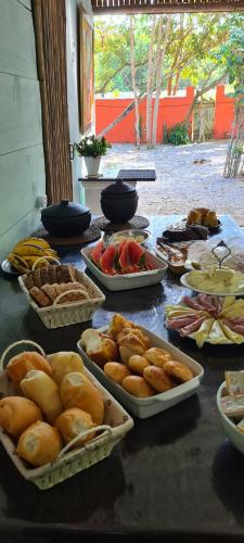 uma mesa com muitos tipos diferentes de alimentos sobre ele em Pousada Cantinho do Sagui em Búzios