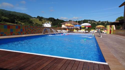 a swimming pool with two water fountains at Conjunto Hotelero La Pasera in Soto de Cangas