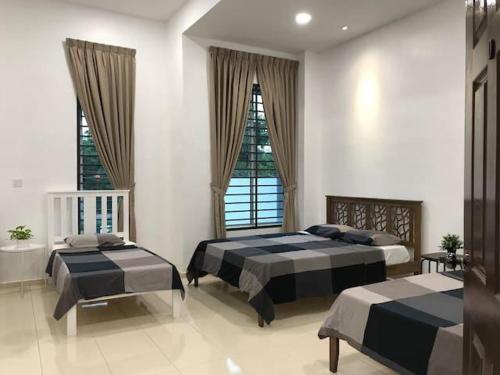 a bedroom with two beds and two windows at G-Homestay @ Sungai Abong Muar*10~20pax in Muar