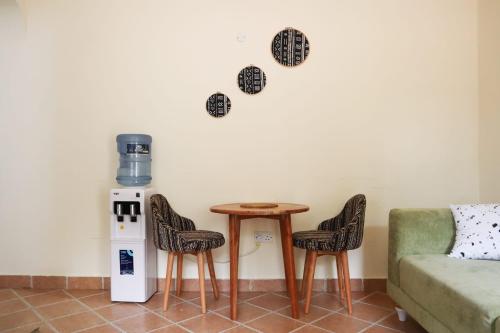 a table and chairs in a living room with a couch at Cosy Living near Bofa Beach in Kilifi