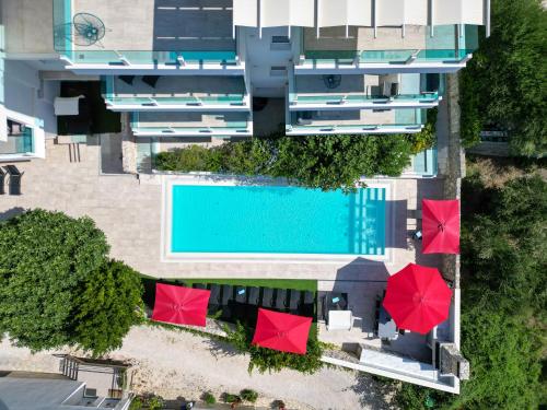 an overhead view of a swimming pool with red umbrellas at Villa Aqua in Zaboric