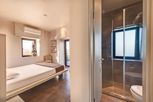 a bedroom with a bed and a shower at Assosyal Hotel in Behramkale