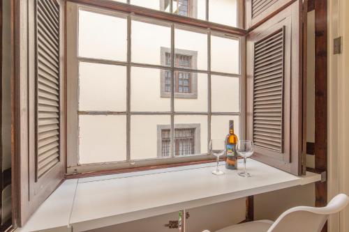 - une fenêtre avec 2 verres et une bouteille de vin dans l'établissement Apartamento Boutique frente a la Playa, à Santa Cruz de la Palma