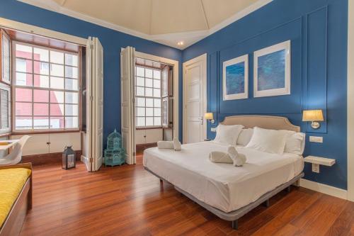 - une chambre avec des murs bleus et un lit avec des oreillers blancs dans l'établissement Apartamento Boutique frente a la Playa, à Santa Cruz de la Palma