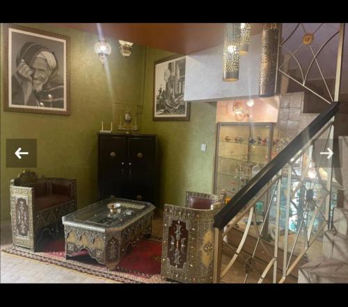 een woonkamer met een trap en een tafel bij Riad en exclusivité Maison d hôtes Chamade & Spa in Marrakesh
