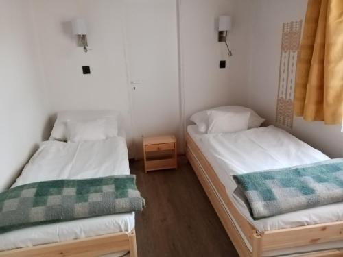 Zimmer mit 2 Betten und einem Nachttisch in der Unterkunft Parti Sétány Vendégház in Balatonkenese