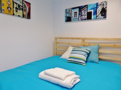 um quarto com uma cama azul com toalhas em Apartamento Embaixador Mateus em Lisboa
