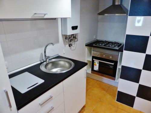 a small kitchen with a sink and a stove at Apartamento Embaixador Mateus in Lisbon
