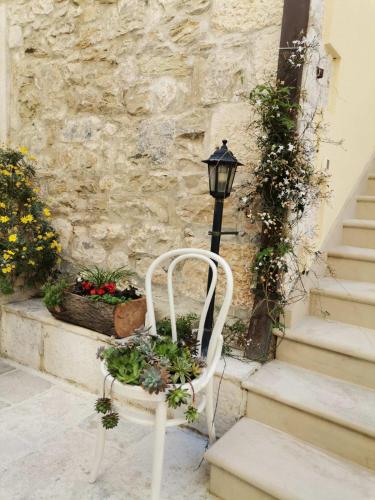 a white chair sitting next to a building with flowers at Luxury Apartment Spa "Marina" in Makarska