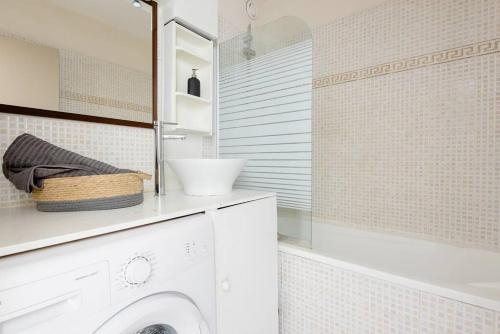 a bathroom with a washing machine and a tub at Park & Suites -wifi-Netflix-vue in Marseille