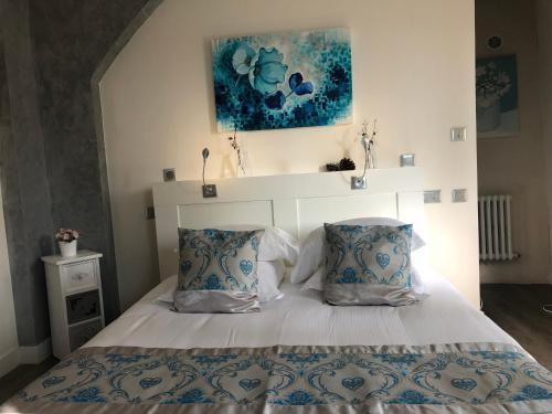 a bedroom with a bed with two pillows at Logis Hôtels Troglododo in Azay-le-Rideau