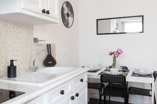 una cucina bianca con un lavello e un bancone di Le charmant Yin-Yang studio proche de Paris a Montrouge