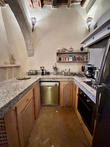 a kitchen with a sink and a stove top oven at Riad Les Sables Bleus, médina, lumineux et terrasse privée sur mer in Essaouira