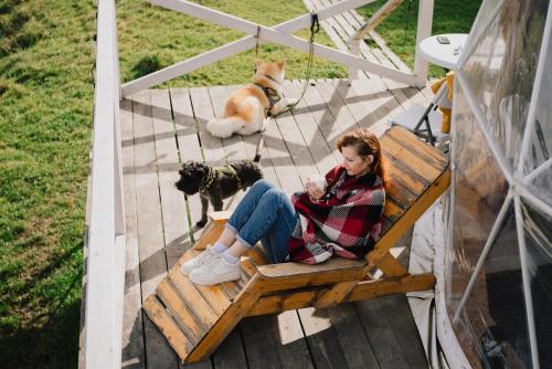 een vrouw op een bank met een hond bij Готель Еко Сфера 