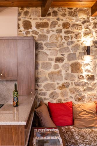 a room with a stone wall with a couch and a table at Stone House in Astérion
