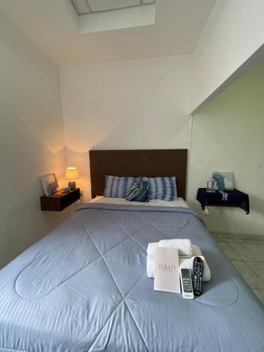 a bedroom with a bed with a remote control on it at Hotel y Café Ixmati Suchitoto in Suchitoto