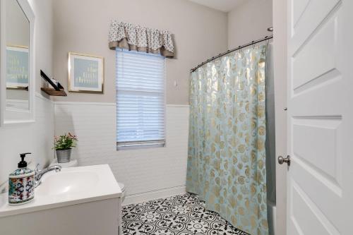 a bathroom with a shower curtain and a sink at E2 Centrally located in Carytown fully fenced in Richmond