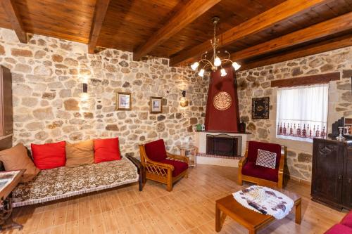 a living room with a couch and a stone wall at Stone House in Astérion