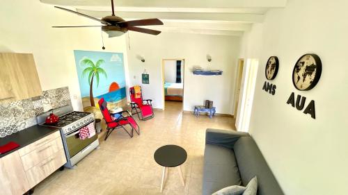 a living room with a couch and a ceiling fan at Very quiet apartment with lots of privacy and a tub on the edge of a national park! in Savaneta