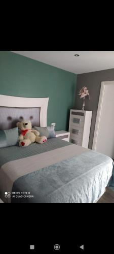 um urso de peluche sentado em cima de uma cama em Casa Patri y Salva em Igualeja