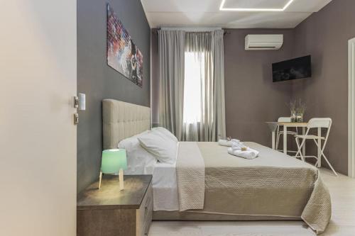 a bedroom with a bed and a table with a chair at Moca Rooms Onda in Bari